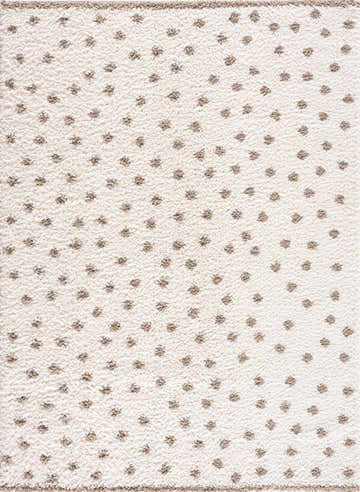 Close-up of Chaia Dotted Cream & Brown Plush Rug. Beige rug with a soft, shag texture and small, evenly spaced brown dots. Design-Rectangle-537
