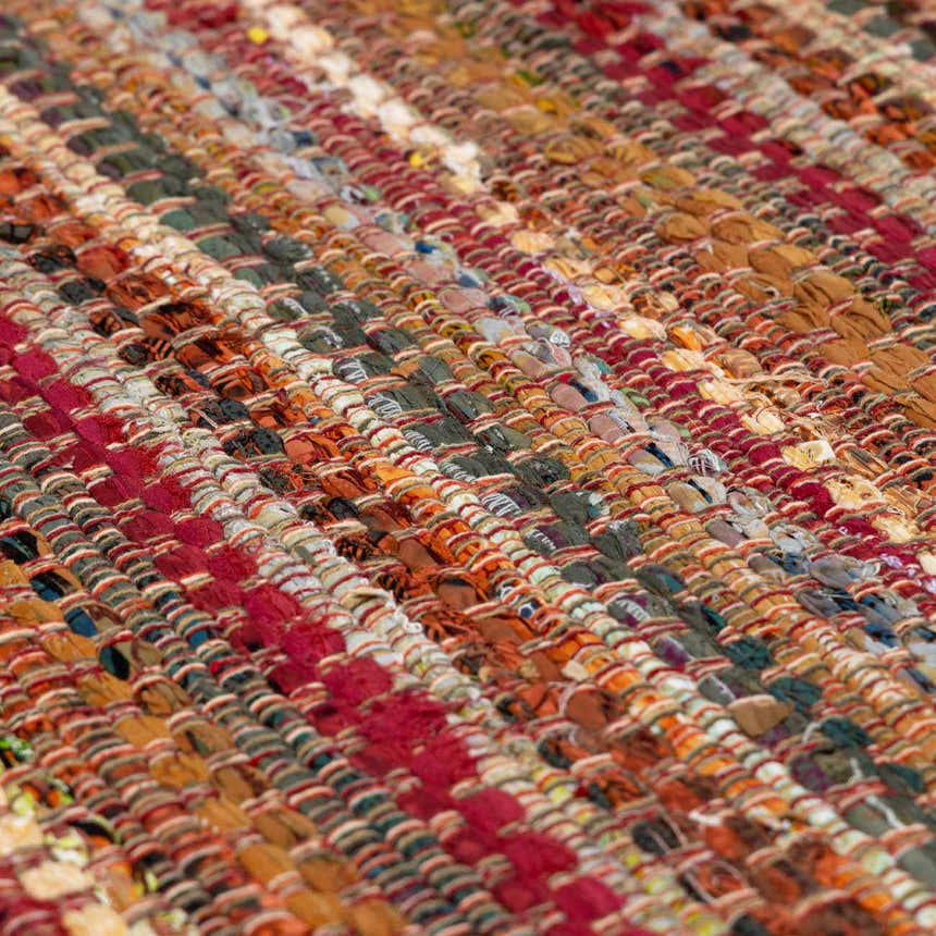 Close-up of the hand woven Brenda Crimson Area Rug, showing its cotton texture and colorful stripes. Texture