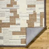 Close-up of the hand-tufted Berker Area Rug. Beige, charcoal, cream, light gray, and taupe geometric pattern in 100% wool. Fold