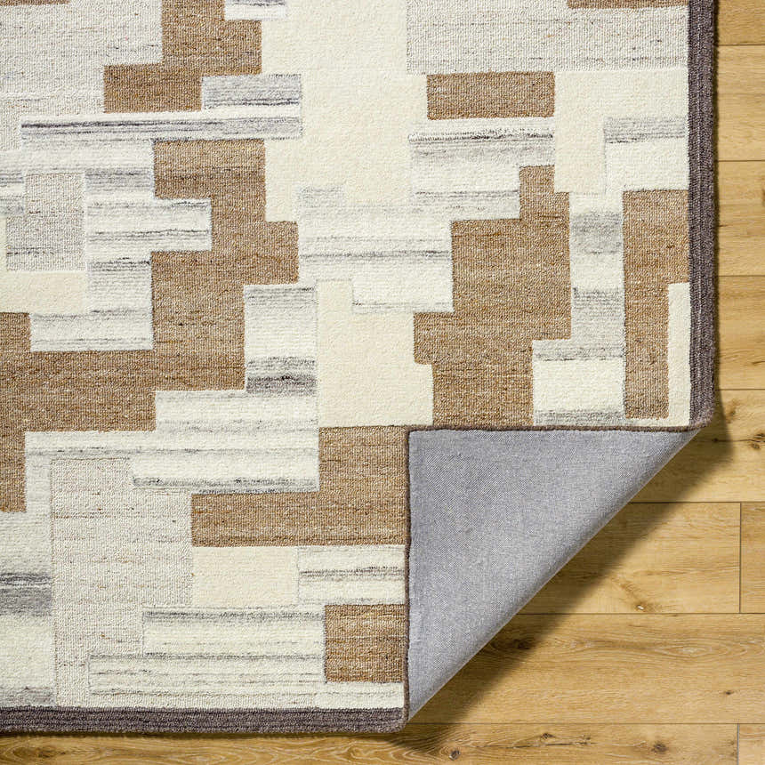 Close-up of the hand-tufted Berker Area Rug. Beige, charcoal, cream, light gray, and taupe geometric pattern in 100% wool. Fold