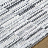 Close-up of Bronco Broken Striped Area Rug. Contemporary design with black, charcoal, gray, and ivory stripes. Texture