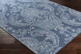 Close-up of the Simpatico Candice Olson x LIVABLISS SPO-1000 Area Rug. Blue wool rug with a white and pale blue paisley pattern. Corner