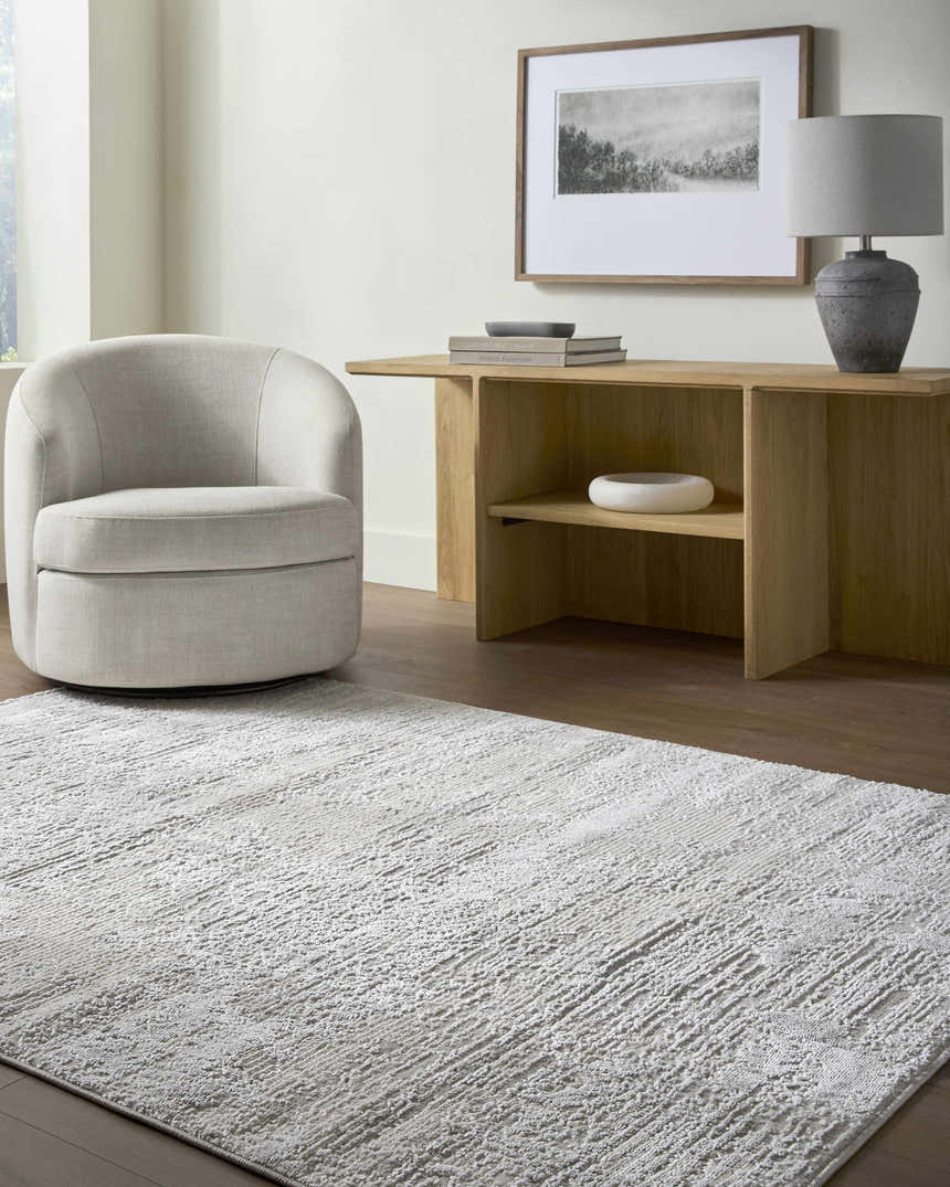 Contemporary living room with a cream swivel chair and the Aramis Area Rug in cream and light gray. Roomscene-Rectangle