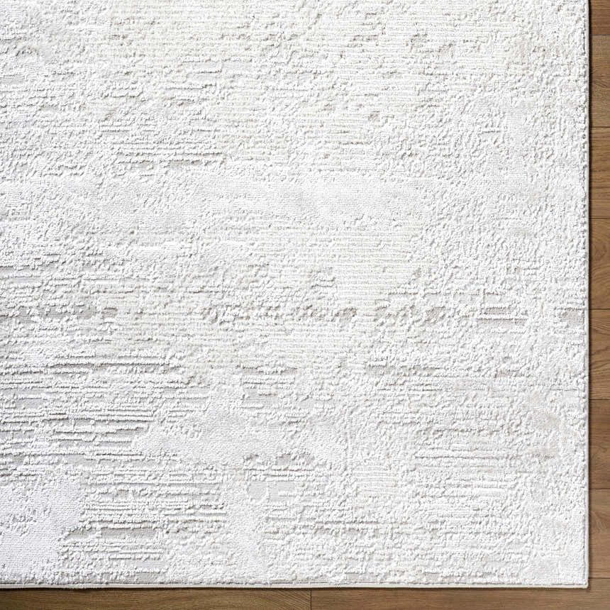 Close up of the cream and ivory Aramis Area Rug showing its textured, contemporary design. Corner