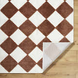 Close-up of the Bosley Brown Washable Area Rug. Features a brown and off-white diamond pattern with a textured pile. Fold