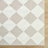 Close-up of the Bosley Beige Washable Area Rug. Beige and cream diamond pattern, machine woven texture. Corner