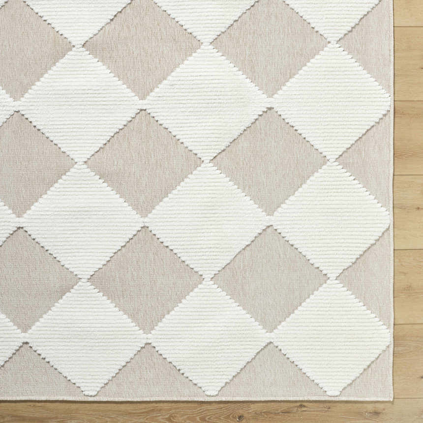 Close-up of the Bosley Beige Washable Area Rug. Beige and cream diamond pattern, machine woven texture. Corner