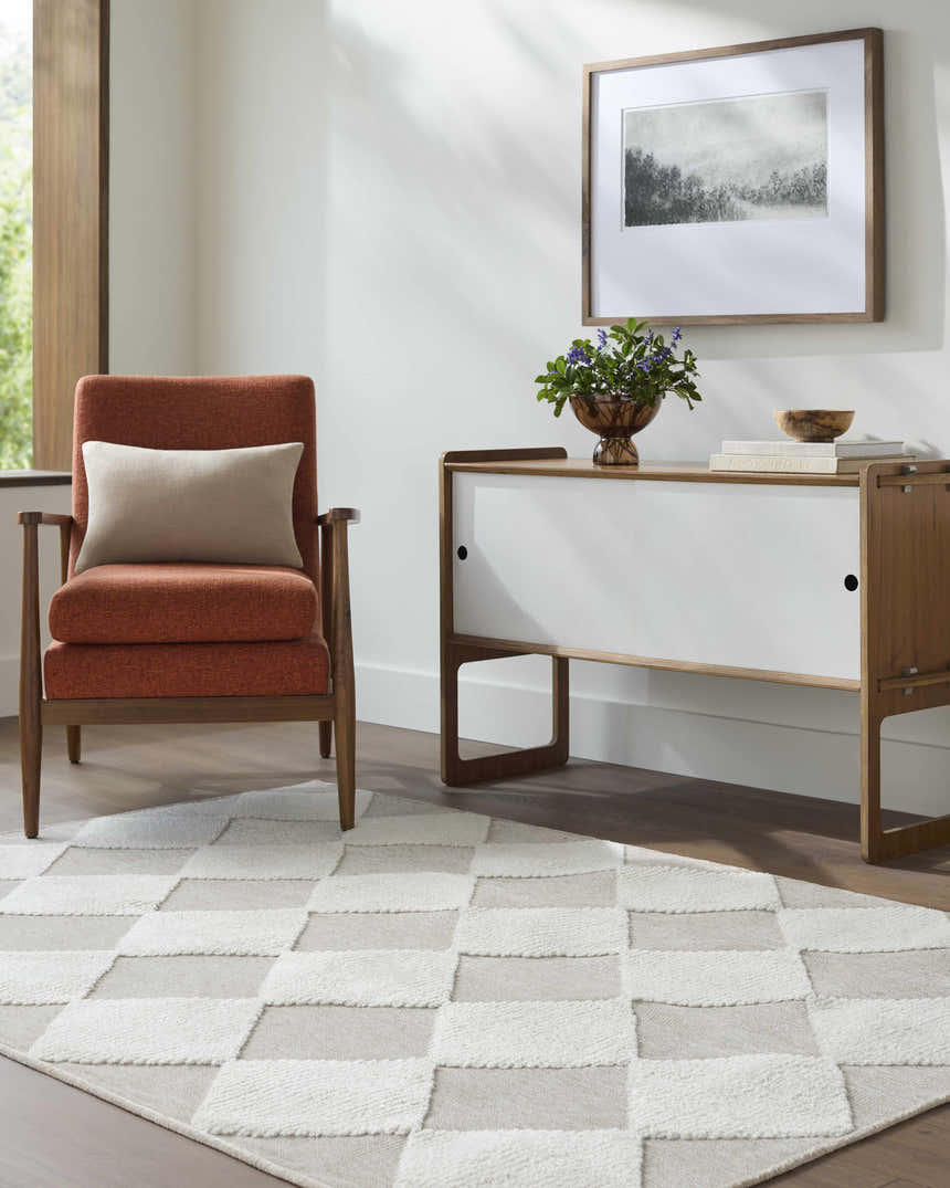 Living room scene with orange chair and Bosley Beige Washable Area Rug featuring a cream and beige checkerboard pattern. Roomscene-Rectangle