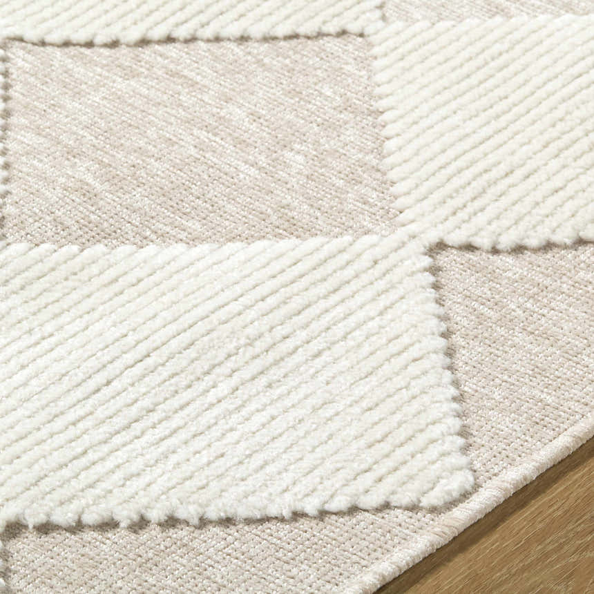 Close-up of the Bosley Beige Washable Area Rug featuring a modern beige and cream checkerboard pattern and plush texture. Texture