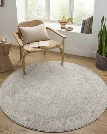 Cozy reading nook with Brynja Slate Blue area rug, woven chair, wood side table, and natural light from a window. Roomscene-Round