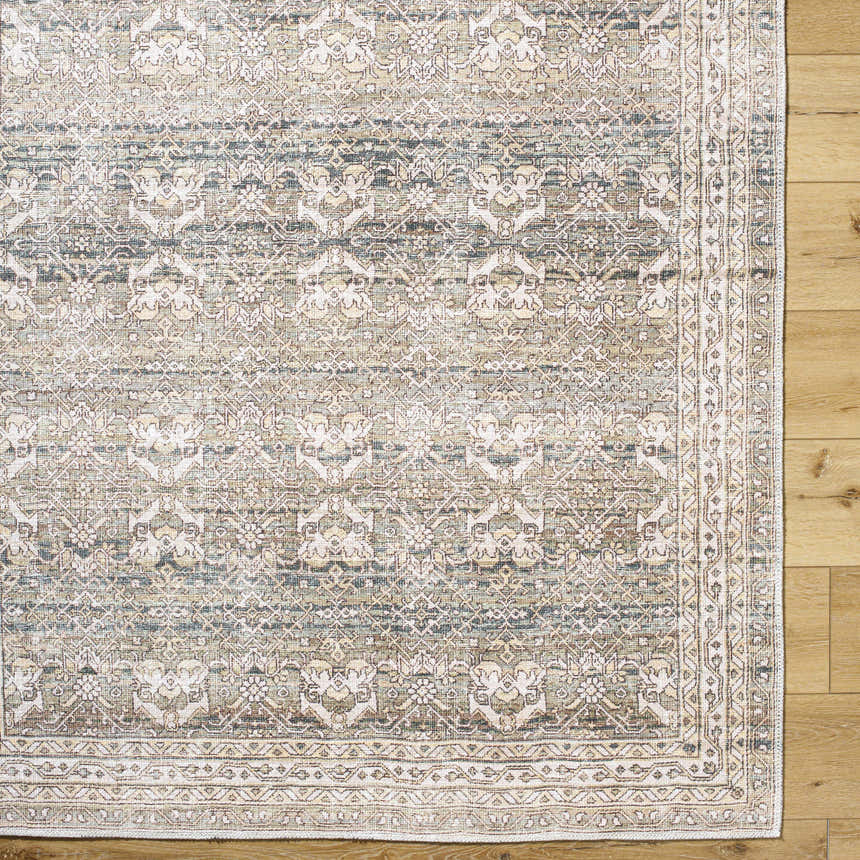 Close-up of the Billie Vintage Flat Pile Washable Rug. Traditional design in cream, green, olive, and peach tones. Corner