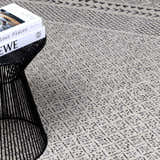 Close-up of Burdette Soft Neutral Rug showing a geometric diamond pattern in charcoal, gray, and off-white. Styleshot