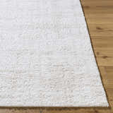Close up of the white, plush texture of the Bianca Area Rug on hardwood flooring. Front