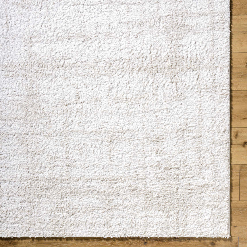 Close-up of the Bianca Area Rug showing its white shag texture on light wood floors. Corner
