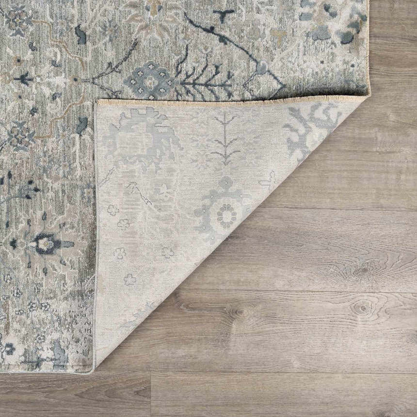 Close-up of the Barkisland Thick Luxe Oushak Rug showing the traditional floral pattern, colors, and machine-woven construction. Fold