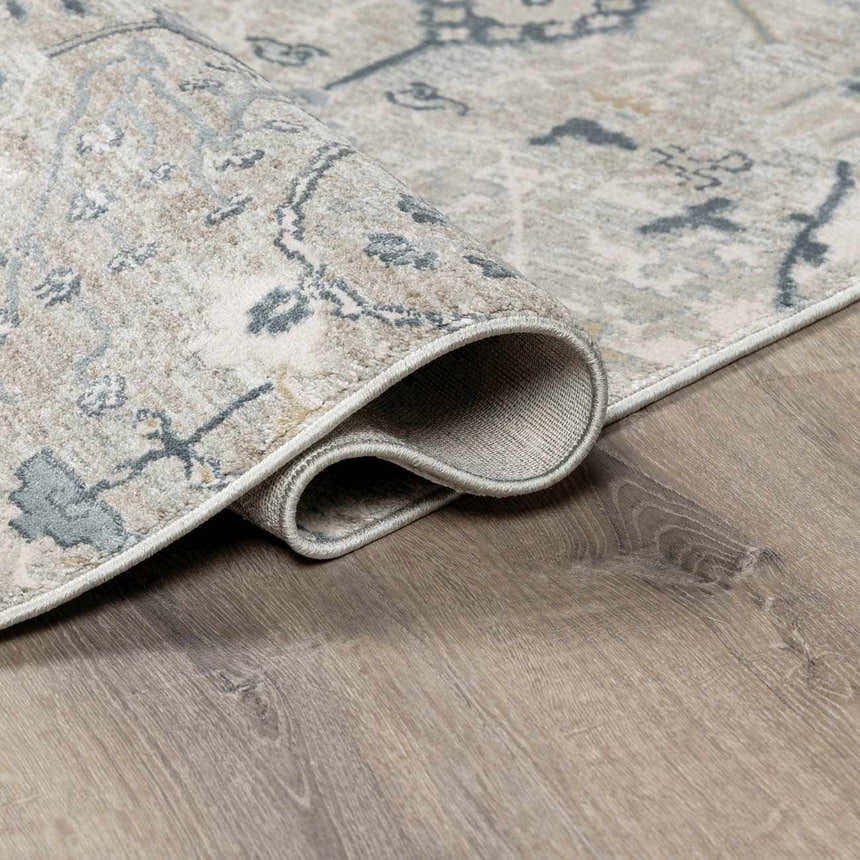 Close-up of the Barkisland Thick Luxe Oushak Rug showing its deep teal, sage, and beige floral pattern and woven texture. Fold