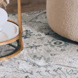 Close-up of the Barkisland Thick Luxe Oushak Rug in light beige, teal, and gray with a floral pattern and a textured weave. Styleshot