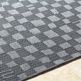 Close up of the Arifah Gray Area Rug showing a woven gray and light gray geometric checkerboard pattern. Texture