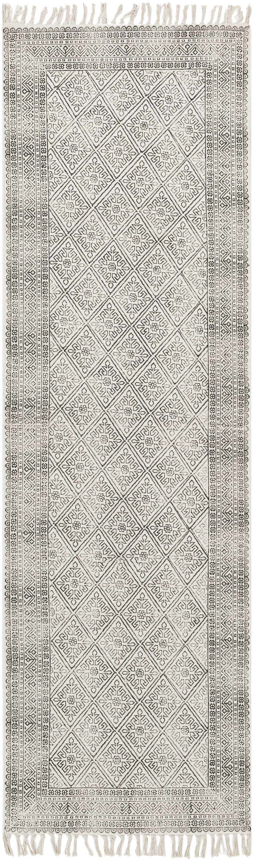 Close-up of the Brushton Area Rug. Beige cotton rug with black geometric diamond pattern and fringe. Hand woven. Design-Runner-268