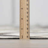 Close-up of the Bristolville Premium Leather Rug showing the pile height with a ruler. Gray and white tones. Pile
