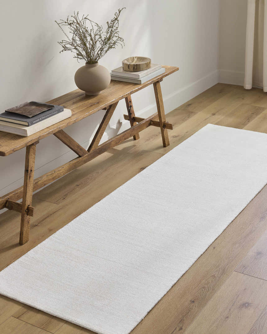 Hallway scene with a white Brownsdale Area Rug runner on wood floors and a rustic wood bench. Roomscene-Runner