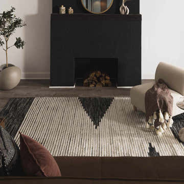 Living room scene with a black fireplace and the cream and black Bushwick Area Rug. Roomscene-Rectangle