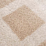 Close-up of the plush Beynon Beige Washable Area Rug, showing its beige and peach geometric design and soft texture. Texture