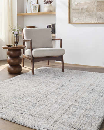 Living room scene with a light gray armchair and Yidia White Solid Area Rug. Roomscene-Rectangle