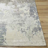 Close-up of Bued Handmade Wool-Blend Rug showing beige, gray, and ivory abstract pattern and textured weave on wood floor. Front