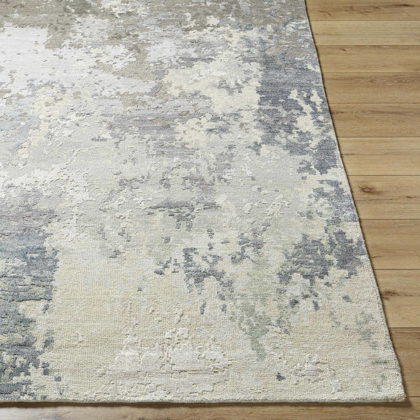Close-up of Bued Handmade Wool-Blend Rug showing beige, gray, and ivory abstract pattern and textured weave on wood floor. Front