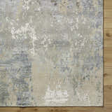Close-up of the Bued Handmade Wool-Blend Rug. Abstract design in beige, brown, gray, teal, and ivory on a textured wool blend. Swatch