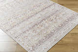 Close-up of Bienna Vintage Flat Pile Washable Rug. Traditional design in camel, cream, dark brown, peach, and tan. Machine woven. Corner