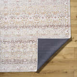 Close-up of Bienna Vintage Flat Pile Washable Rug showing camel, cream, brown, and peach traditional pattern and texture. Fold