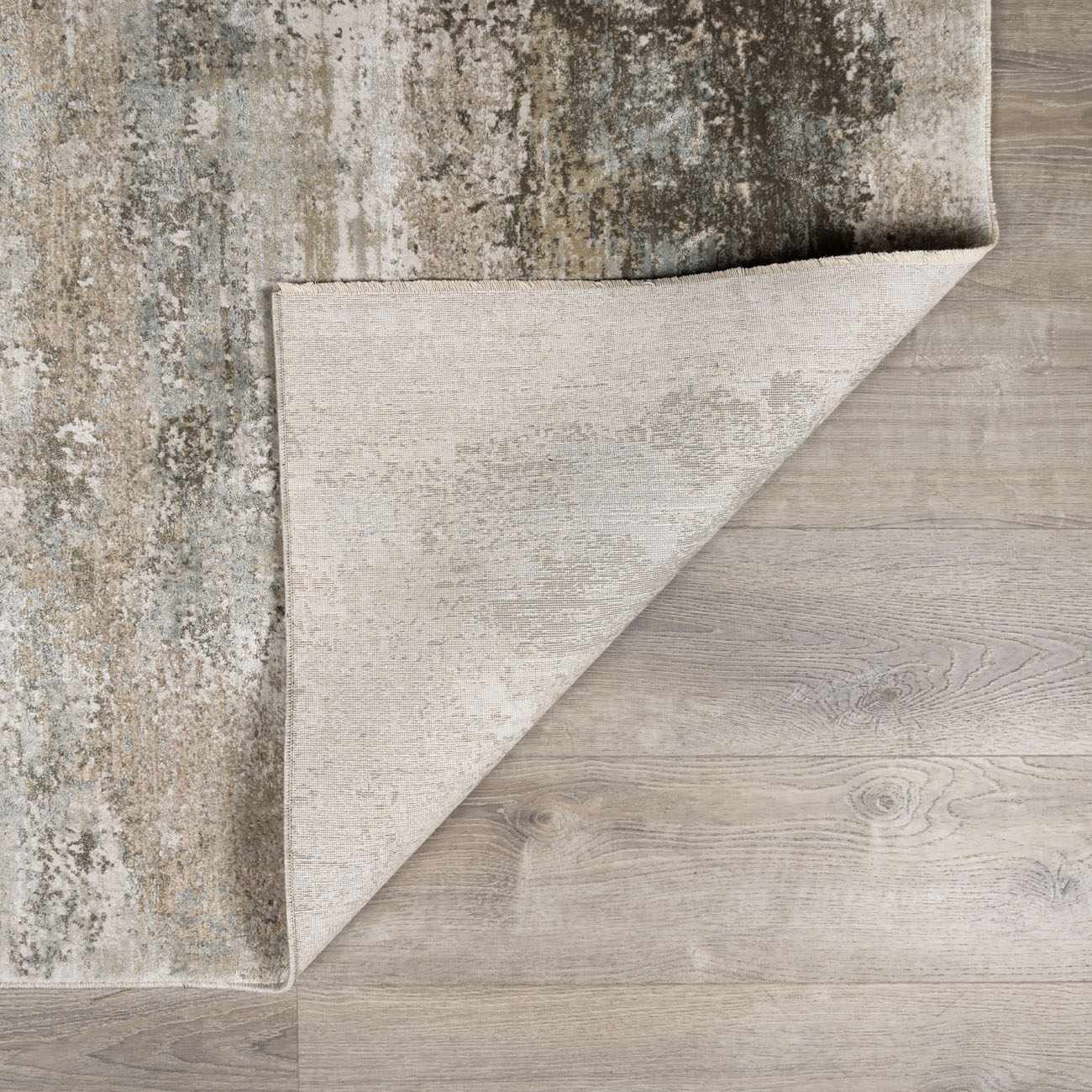 Close-up of the Bowdoinham Thick Luxe Boutique Rug showing its charcoal, sage, and taupe abstract pattern and woven texture. Fold