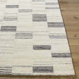 Close-up of Max Handmade Becki Owens x LIVABLISS BOMX-2305 Area Rug. Cream wool rug with ash and charcoal geometric pattern. Front