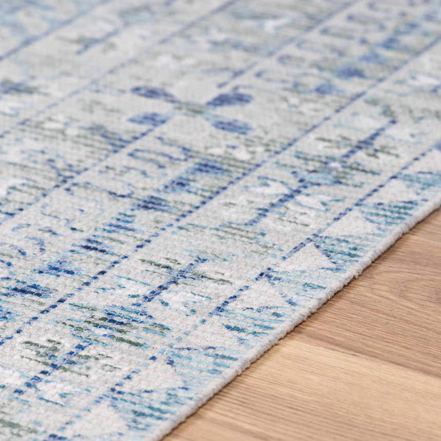 Close-up of Byers Handmade Cotton-blend Aqua Rug showing its hand woven texture and blue, green, and white pattern. Texture