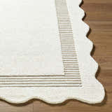 Close-up of the Tono Ivory Border Hand Tufted Wool Area Rug showing the wool texture, striped border, and scalloped edge. Front