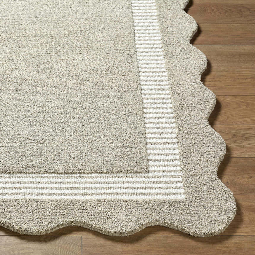 Close-up of the Fanae Beige Border Hand Tufted Wool Area Rug showing texture, striped border, and scalloped edge. Front