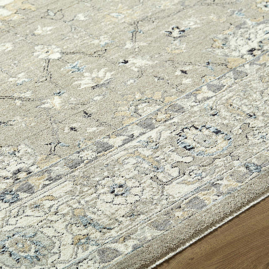 Close-up of the Briony Area Rug showcasing its traditional gray, ivory, and blue floral pattern and soft texture. Texture