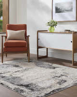 Living room scene with the ash, light silver, and silver gray Birdie Area Rug, orange chair, and white cabinet. Roomscene-Rectangle
