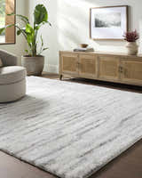 Living room with a gray swivel chair and the Benjen Gray Area Rug. Neutral tones and natural light. Roomscene-Rectangle