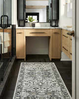 Bathroom scene with a black herringbone floor and a Cabacungan Washable Area Rug in black, gray, and beige. Roomscene-Runner
