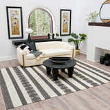 Living room scene with a black round coffee table on the striped Whittington Black&White Wool Rug. Cream sofa and modern decor. Roomscene-Rectangle