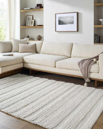Living room scene with a cream sectional sofa and a textured ivory Coskun Area Rug. Roomscene-Rectangle
