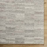 Close-up of the hand-tufted Andred Taupe Area Rug. Beige, cream, and taupe wool rug with subtle horizontal stripes. Corner