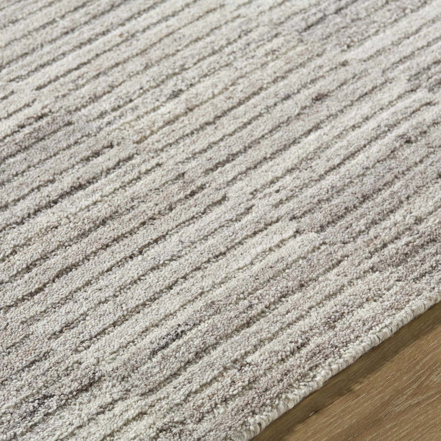Close up of the hand tufted Andred Taupe Area Rug. Beige, cream, and tan wool rug with a subtle striped pattern. Texture