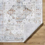 Close-up of the Cargan Area Rug showing its traditional burnt orange, cream, and navy pattern and machine-woven texture. Fold