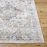 Close-up of the Cargan Area Rug showing its cream base with burnt orange, navy, and tan traditional pattern. Front