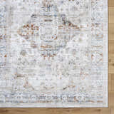 Close-up of the Cargan Area Rug. Traditional design in cream, burnt orange, navy, and tan on a wood floor. Corner