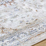 Close-up of the Cargan Area Rug. Cream rug with burnt orange, navy, and light gray traditional pattern. Texture